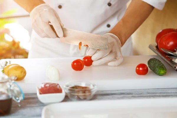 Mãos com faca corte de tomate . — Fotografia de Stock
