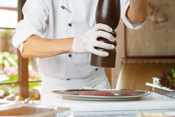 Mãs mãos com dispensador de pimenta . — Fotografia de Stock