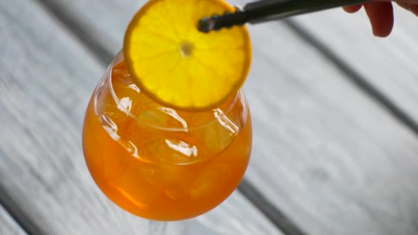 Zange steckt Orange in Cocktail. — Stockvideo