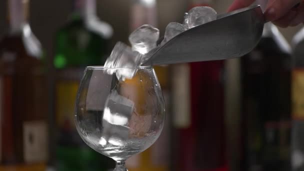 Лед медленно падает в бокал . — стоковое видео