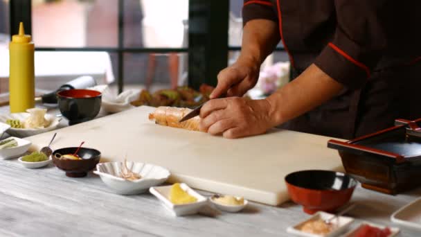 Руки розрізають суші ножем . — стокове відео