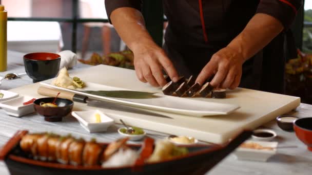 Hands putting sushi onto plate. — Stock Video