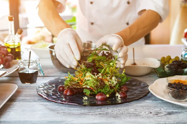 Mãos de cozinheiro fazendo salada . — Fotografia de Stock