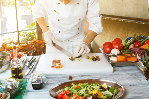 Hand med kniv skära oliv. — Stockfoto