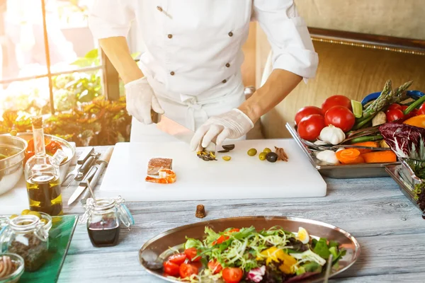 Manos con cuchillo de aceitunas cortadas . — Foto de Stock