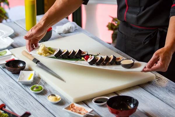 Manos sosteniendo plato con sushi . —  Fotos de Stock