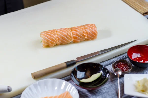 Rollo de sushi en la tabla de cocinar . — Foto de Stock
