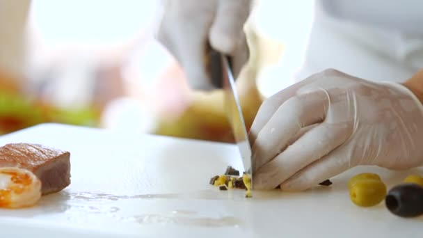 Hand with knife cutting olive. — Stock Video