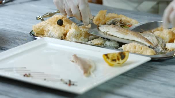 Лопатка кладет рыбу на тарелку . — стоковое видео