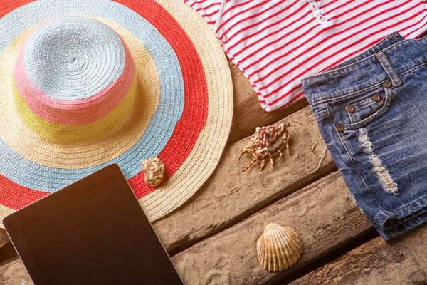 Sombrero de playa y tableta negra . — Foto de Stock