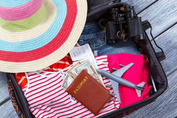 Suitcase with clothes and binoculars. — Stock Photo, Image