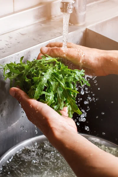 Handen wassen roquette bladeren. — Stockfoto