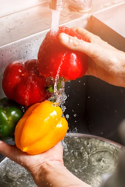 Mans hands wash red paprika. — Stock Photo, Image