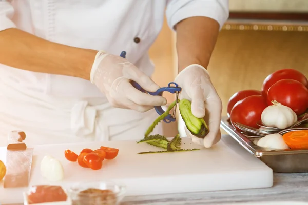 Mans hands peeling cucumber. — Stock Photo, Image