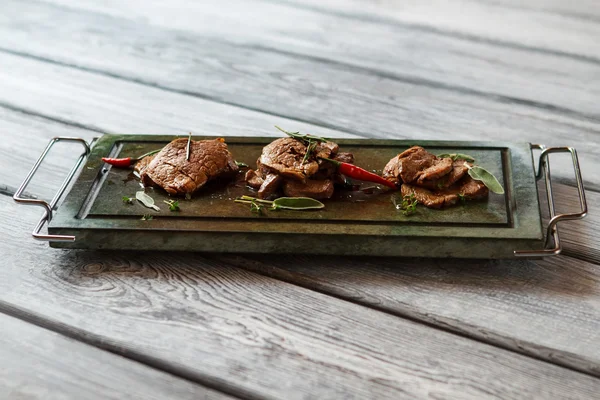 Dark green tray with meat. — Stock Photo, Image