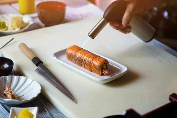 Fakkel brander over sushi rollen. — Stockfoto