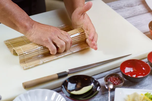Mannelijke handen houdt bamboe mat. — Stockfoto