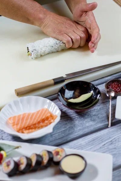Мужские руки касаются суши-ролла . — стоковое фото