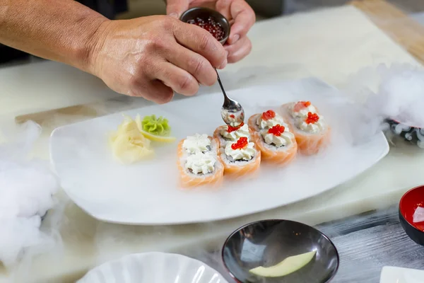 Κουτάλι χαβιάρι βάζει πάνω στο σούσι. — Φωτογραφία Αρχείου