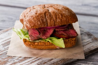 Gri ahşap tahta üzerinde sandviç.