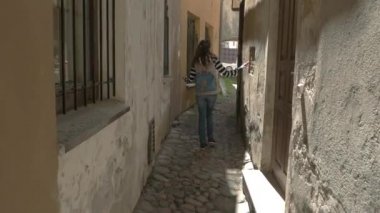 Bayan binalar arasında yürüyor.