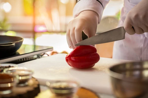 Hand med kniv skär paprika. — Stockfoto