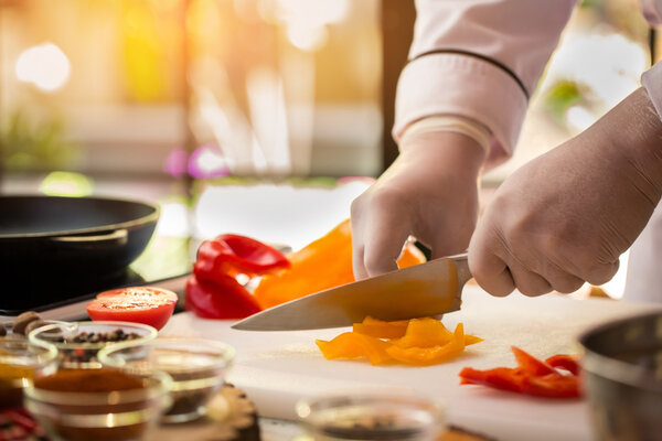 Knife cuts yellow paprika. Pieces of bell pepper. Prepare salad with juicy vegetables. True professional of cooking.
