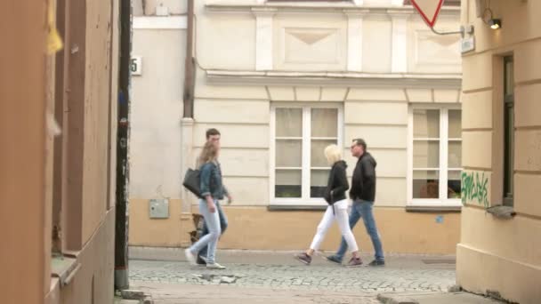 Människor gå längs smala gatan. — Stockvideo