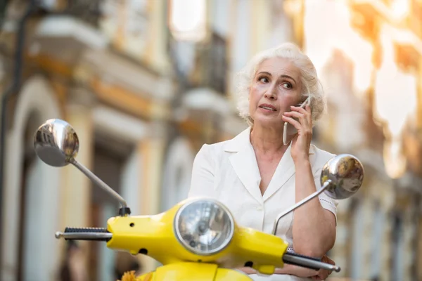 Woman on scooter with phone. — Stock Photo, Image