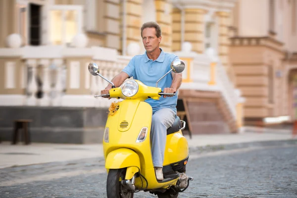 Hombre adulto monta scooter amarillo . —  Fotos de Stock