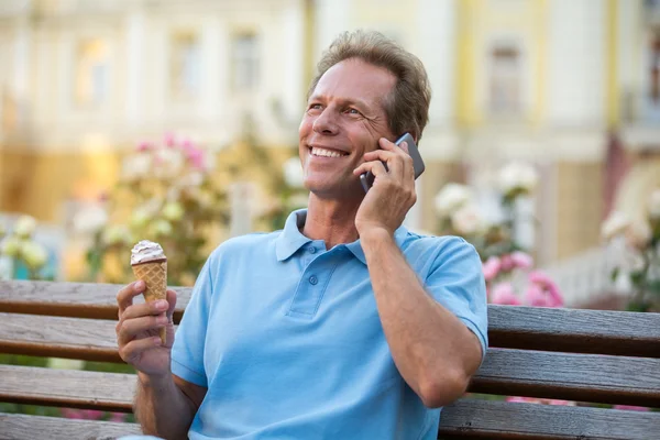 Mature man with phone smiling. — Stock Photo, Image