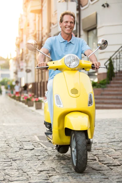 Volwassen man op gele scooter. — Stockfoto