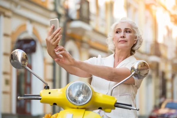 Взрослая женщина смотрит на телефон . — стоковое фото
