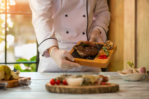 Las manos sostienen el tablero con carne . —  Fotos de Stock