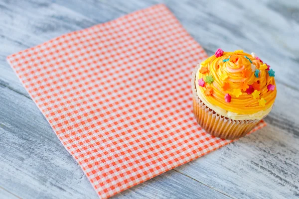 Cupcake en servilleta a cuadros roja . — Foto de Stock