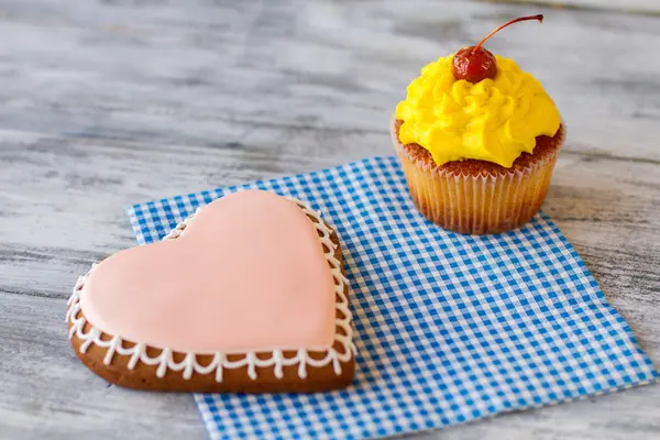 Biscoito de coração e cupcake amarelo . — Fotografia de Stock