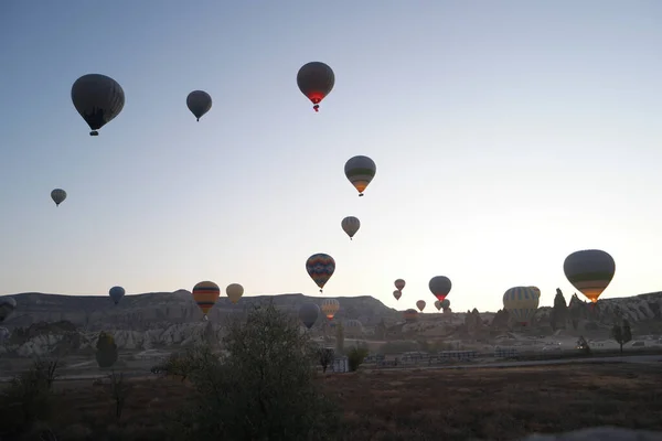 Hete lucht ballonnen vliegen over rotsachtige landschap. — Stockfoto