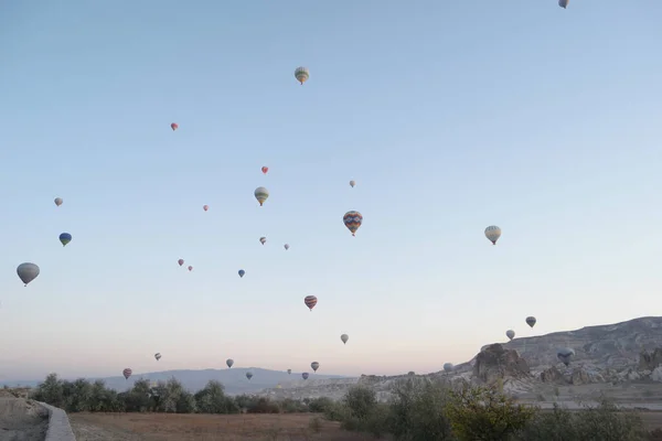 Panoramisch uitzicht op hete lucht ballonnen vliegen over bergen. — Stockfoto