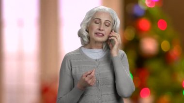 Plastik telefon kullanan emekli bir kadın..