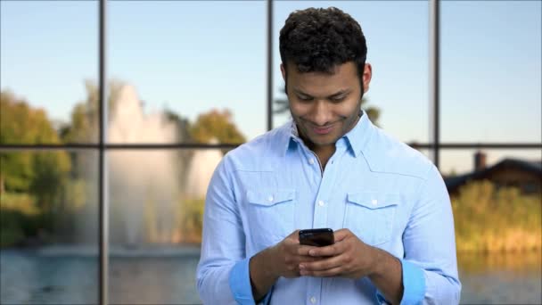 Hombre guapo usando la aplicación en su teléfono inteligente. — Vídeo de stock