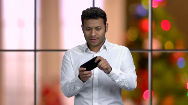 Energetic businessman playing game on smartphone. — Stock Video