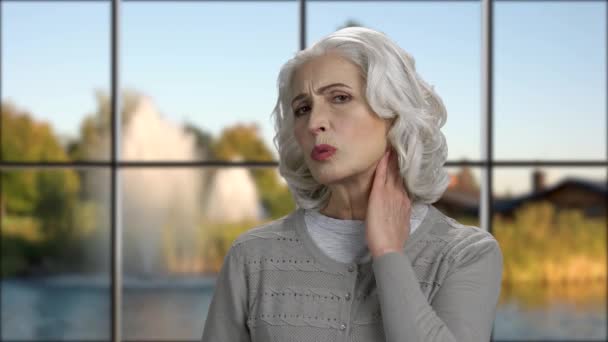 Закройте пожилую женщину, страдающую от боли в шее. — стоковое видео