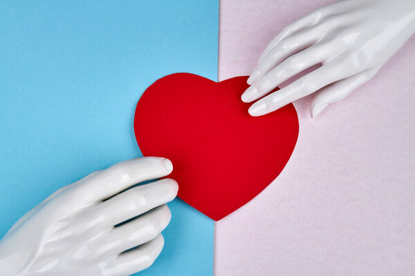 Руки манекена и красное сердце.