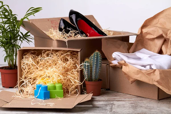 Uitgepakt dozen met schoenen, kleding en speelgoed. — Stockfoto