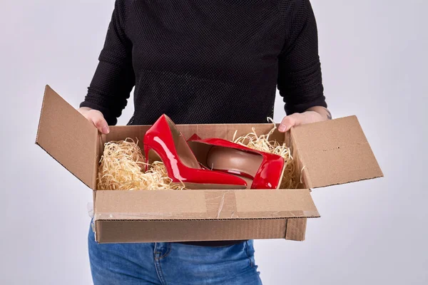 Koerier meisje houdt open doos met schoenen. — Stockfoto