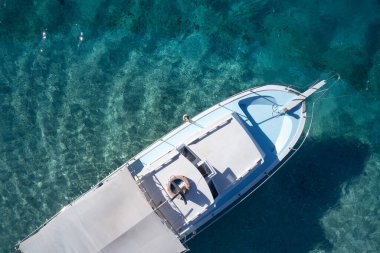 Açık turkuaz sudaki teknenin üst görüntüsü.