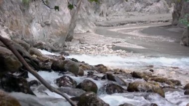 Kayalık dağ nehrinde hızlı su akıyor. Yaklaş.