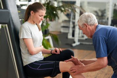 Spor salonunda dizleri ağrıyan sağlıklı genç bir kadın..