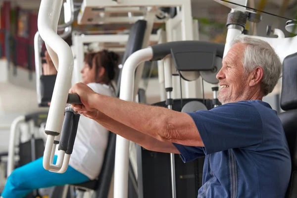 Hombre mayor de entrenamiento en el gimnasio, vista lateral. — Foto de Stock