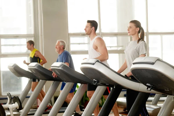 Jóvenes en cinta de correr en el gimnasio. — Foto de Stock